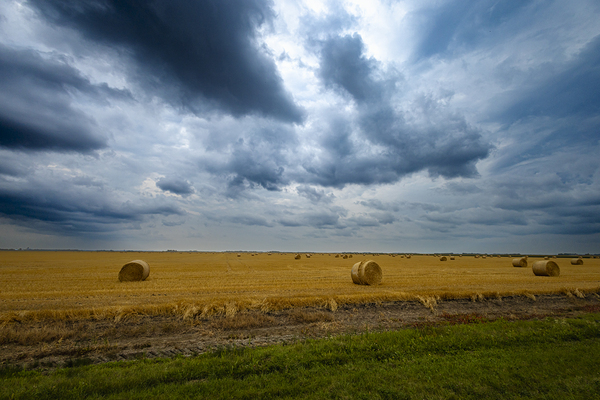 Hay Bales Under a Cloudy Sky Print